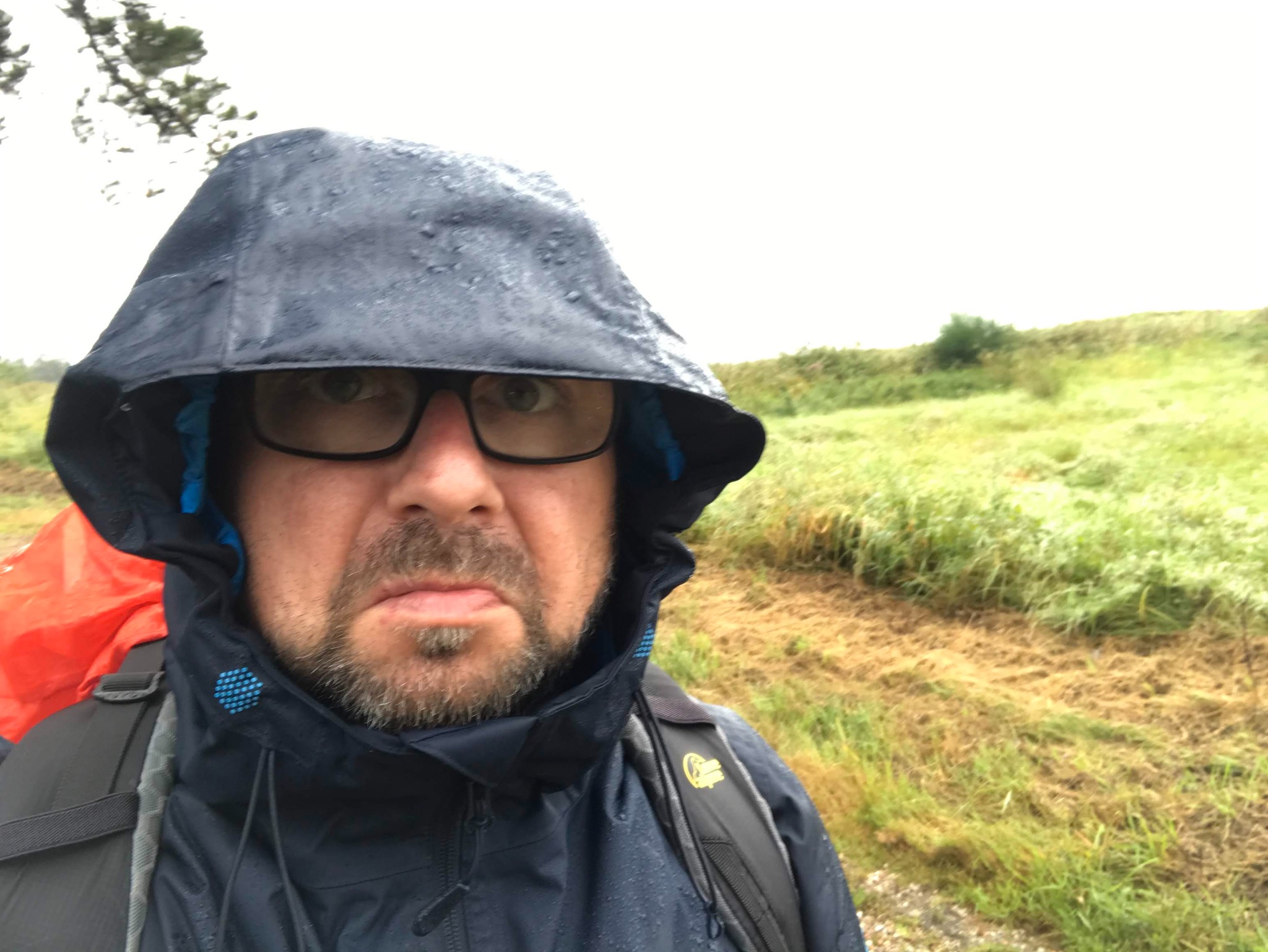 Roberto bei Regen mit Kapuze und Rucksack